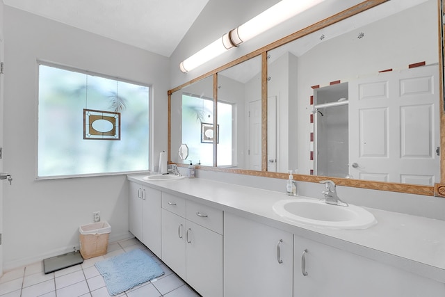 full bathroom featuring lofted ceiling, double vanity, a sink, and a healthy amount of sunlight