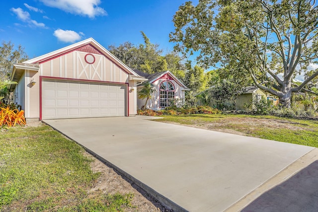 view of front of house with an attached garage, board and batten siding, concrete driveway, and a front yard