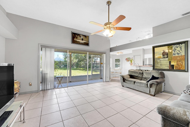 living room with light tile patterned floors, baseboards, visible vents, and a ceiling fan