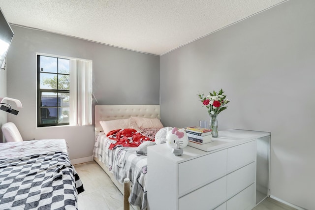 bedroom featuring baseboards and a textured ceiling