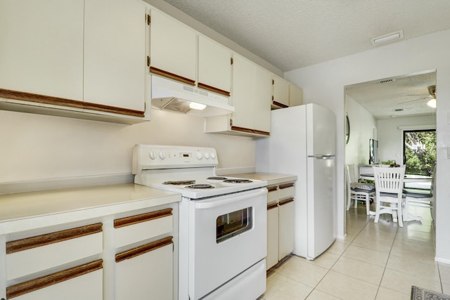 kitchen featuring white appliances, light countertops, under cabinet range hood, and white cabinets