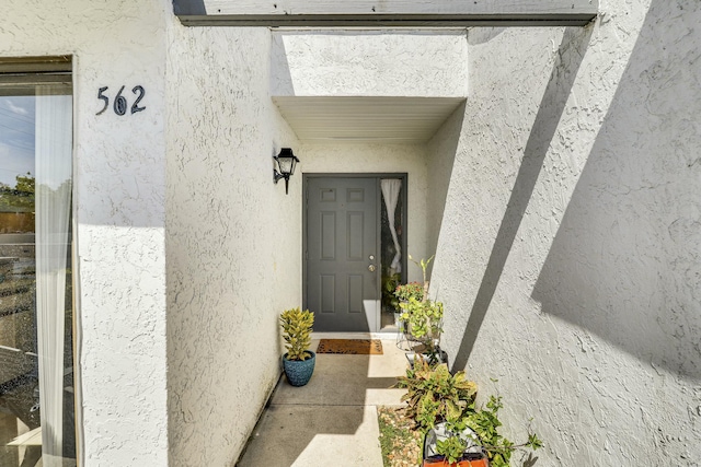 entrance to property featuring stucco siding