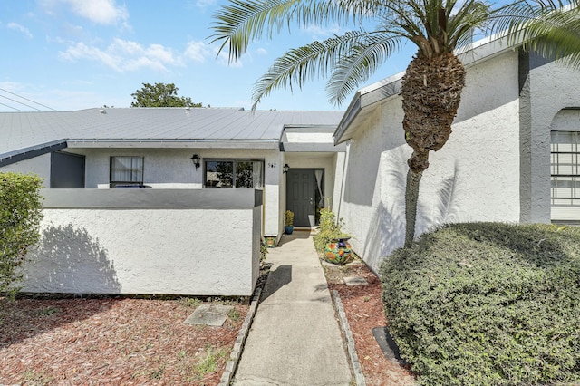 doorway to property featuring stucco siding