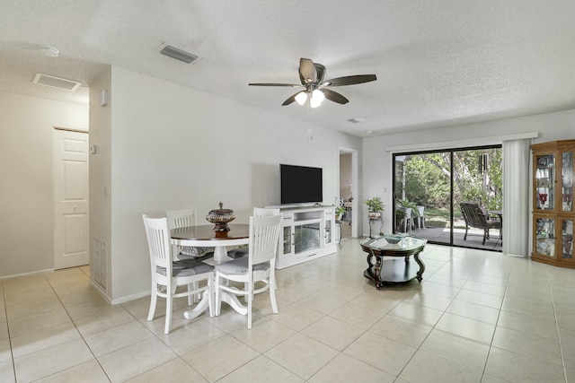 dining space with baseboards, visible vents, ceiling fan, a textured ceiling, and light tile patterned flooring