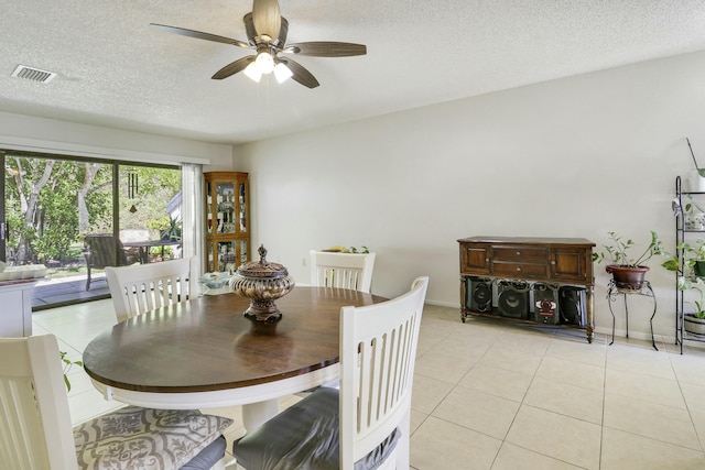 dining space featuring ceiling fan, a textured ceiling, baseboards, and light tile patterned floors