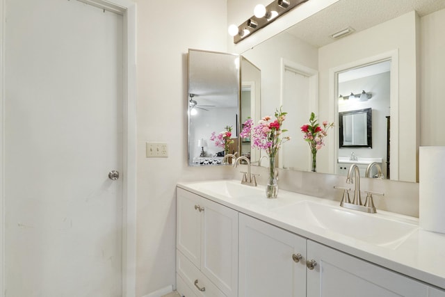 full bath featuring ceiling fan, double vanity, a sink, and visible vents