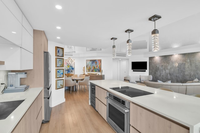 kitchen with decorative light fixtures, stainless steel appliances, light countertops, white cabinets, and modern cabinets