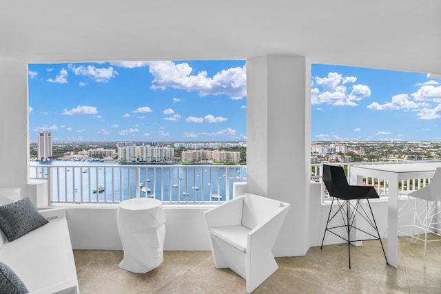 balcony featuring a water view and a city view