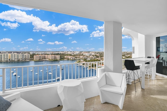 balcony with exterior bar and a water view