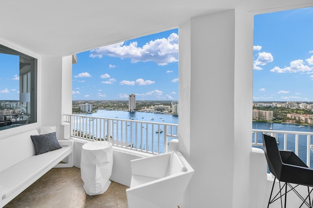 balcony featuring a water view and a city view