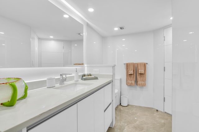 bathroom featuring recessed lighting, concrete floors, vanity, and toilet