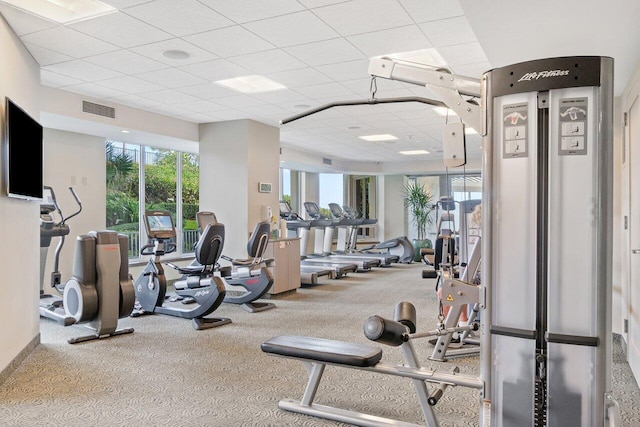 gym with a paneled ceiling and visible vents