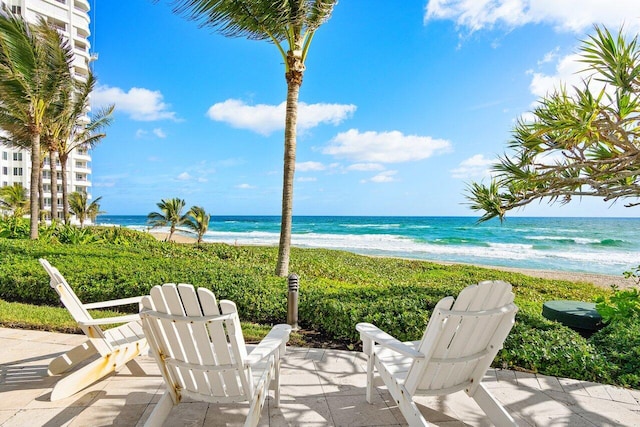 view of patio / terrace featuring a water view and a beach view