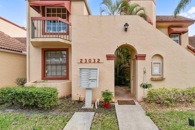 property entrance featuring a tile roof and stucco siding