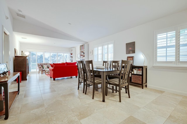 dining area featuring lofted ceiling, visible vents, and baseboards