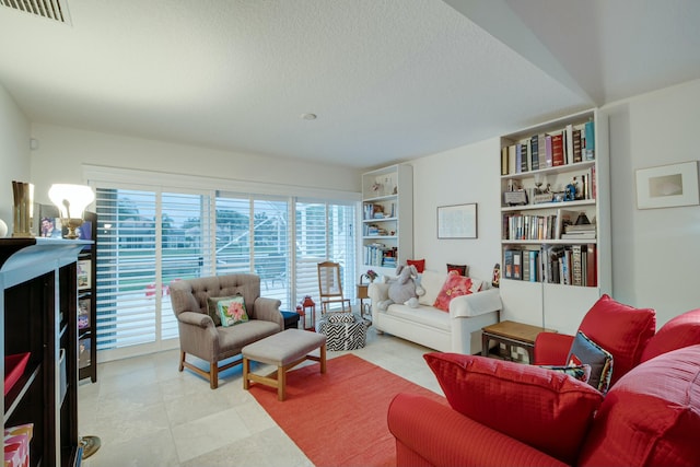 living area featuring a textured ceiling and visible vents