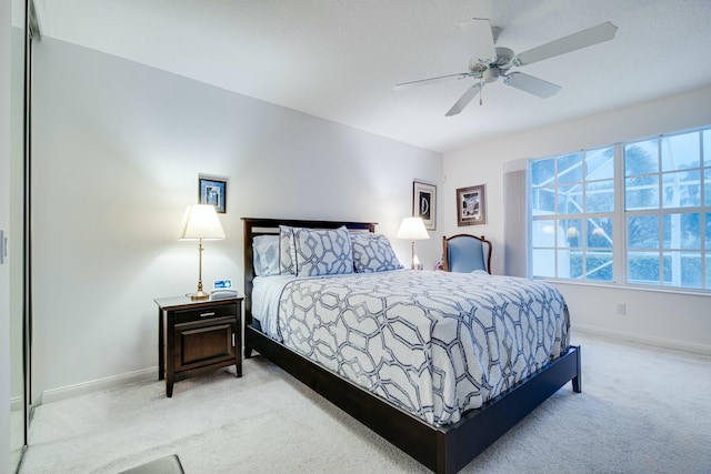 bedroom featuring baseboards, ceiling fan, and light colored carpet