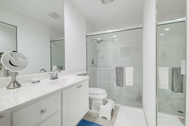 full bath featuring toilet, tile patterned flooring, a shower stall, and vanity