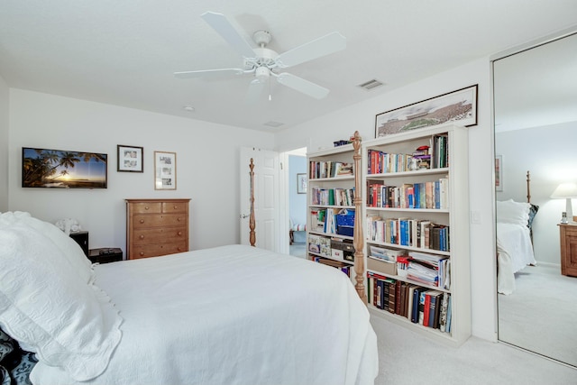 carpeted bedroom featuring a ceiling fan and visible vents