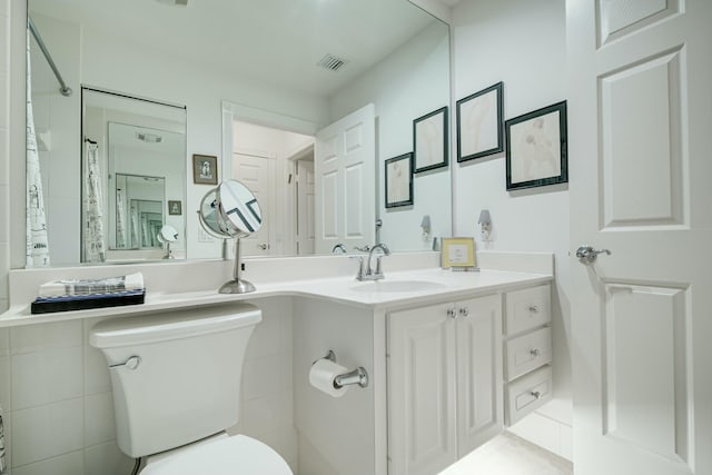 bathroom with toilet, visible vents, and vanity