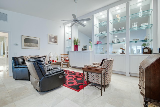 living room with ceiling fan, vaulted ceiling, and visible vents