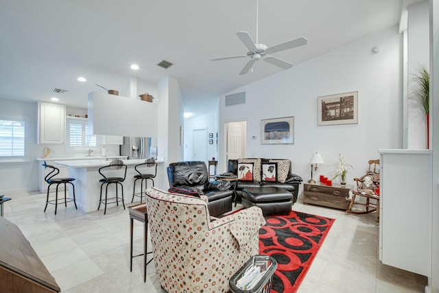 living room featuring a ceiling fan, visible vents, and vaulted ceiling