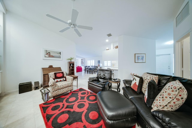 living area featuring lofted ceiling, light tile patterned floors, ceiling fan, and visible vents