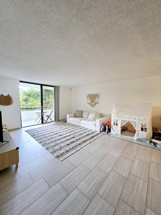 unfurnished living room featuring floor to ceiling windows and a textured ceiling