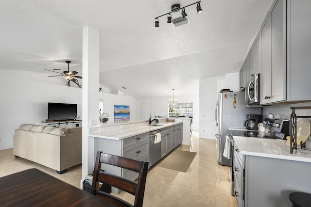 kitchen featuring lofted ceiling, appliances with stainless steel finishes, open floor plan, gray cabinets, and light countertops