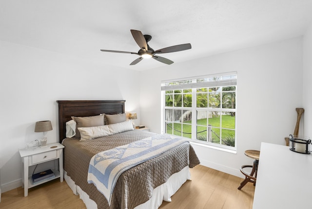 bedroom with light wood-type flooring, ceiling fan, and baseboards