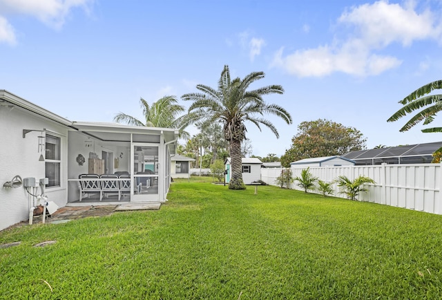 view of yard featuring a sunroom and a fenced backyard