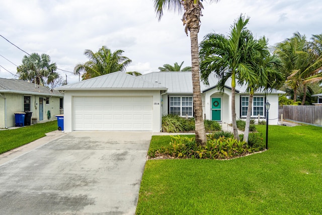 ranch-style house with stucco siding, an attached garage, metal roof, driveway, and a front lawn