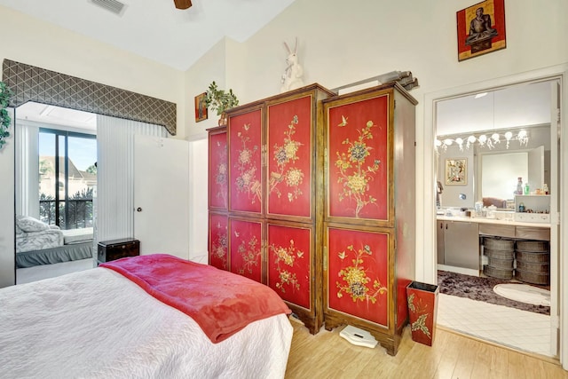 bedroom with visible vents, connected bathroom, and light wood-style flooring