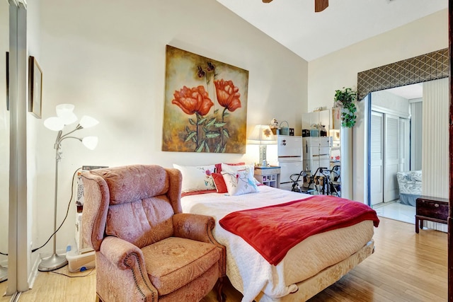 bedroom with a closet, a ceiling fan, vaulted ceiling, and wood finished floors