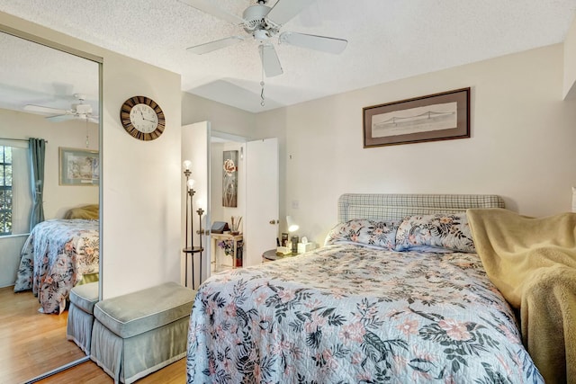 bedroom featuring a ceiling fan, a textured ceiling, and light wood finished floors