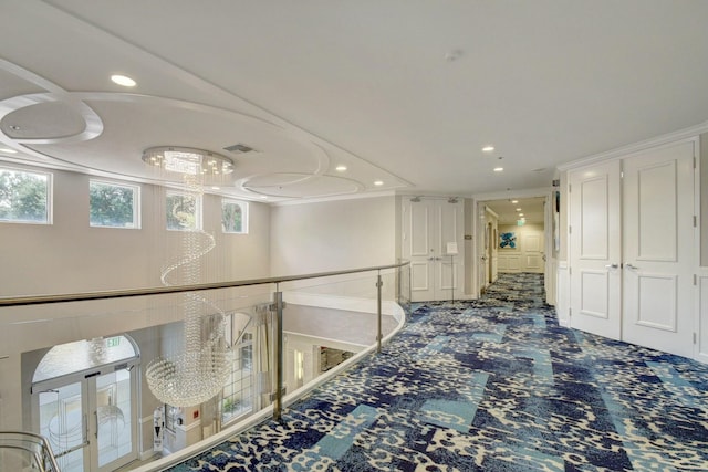 hallway with carpet floors, an upstairs landing, and recessed lighting