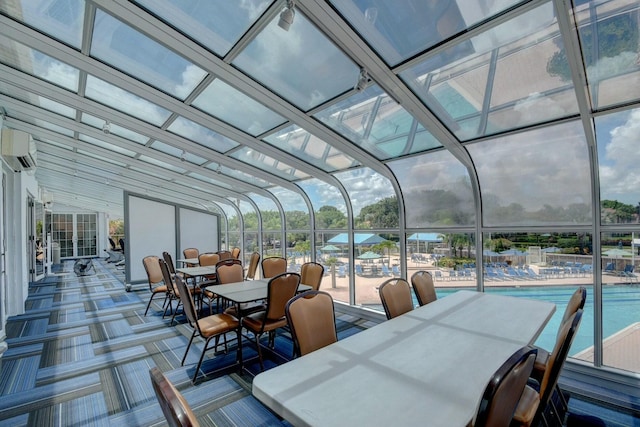 view of patio featuring outdoor dining space, a wall unit AC, and a community pool