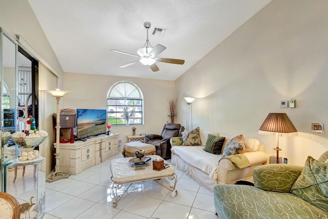 tiled living area with vaulted ceiling, visible vents, and a ceiling fan