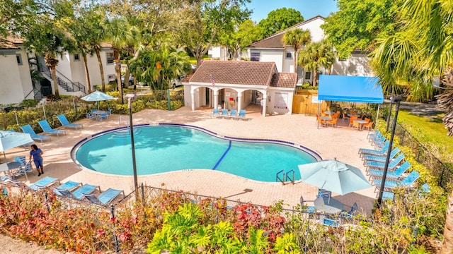 community pool with fence and a patio