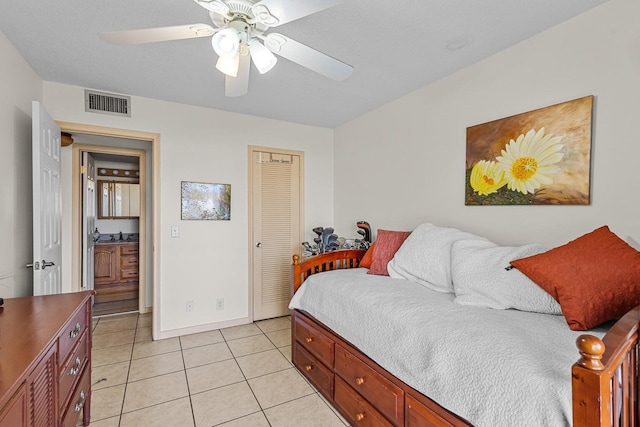 bedroom featuring light tile patterned floors, visible vents, baseboards, a ceiling fan, and a closet