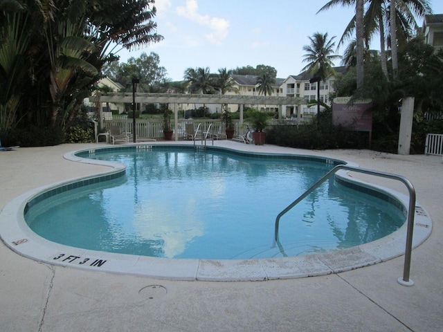 community pool featuring fence and a patio