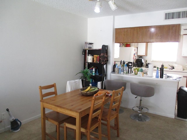 dining room with visible vents, light carpet, ceiling fan, a textured ceiling, and baseboards