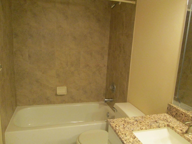 bathroom with toilet, vanity, and  shower combination