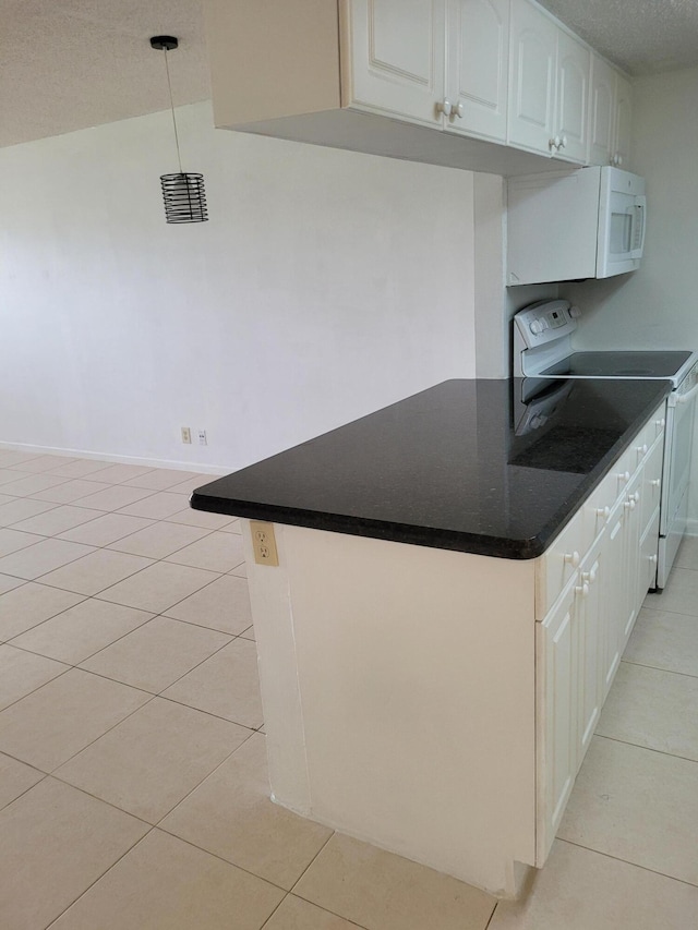 kitchen with light tile patterned floors, white microwave, and range with electric cooktop
