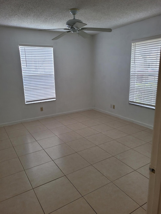 unfurnished room featuring baseboards, a textured ceiling, and a ceiling fan