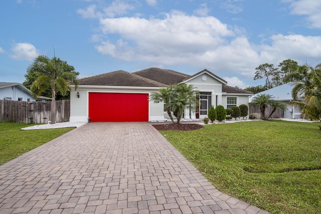 ranch-style home with a garage, fence, decorative driveway, stucco siding, and a front lawn