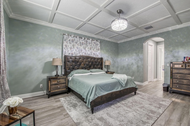 bedroom featuring arched walkways, coffered ceiling, wood finished floors, visible vents, and baseboards