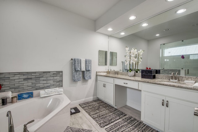 bathroom with double vanity, a sink, a bath, and a shower stall