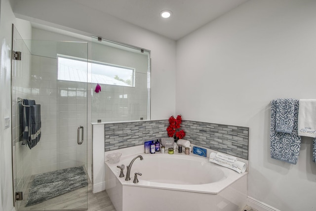 full bath featuring recessed lighting, a garden tub, and a shower stall