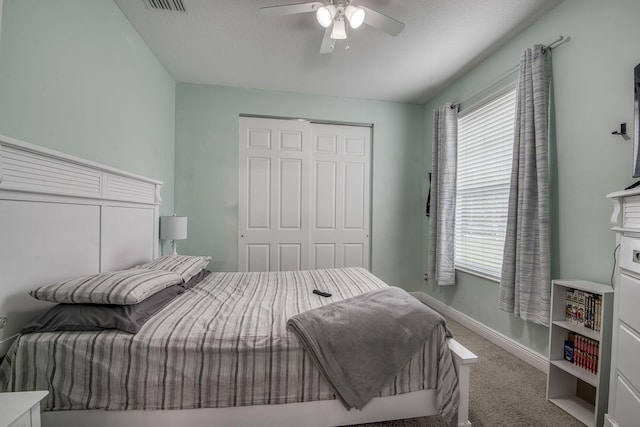 bedroom featuring carpet floors, a closet, visible vents, ceiling fan, and baseboards